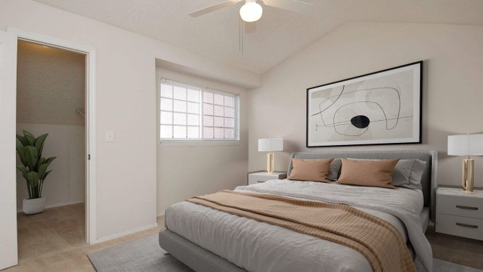 a bedroom with a ceiling fan and white bed at The Palm Haven