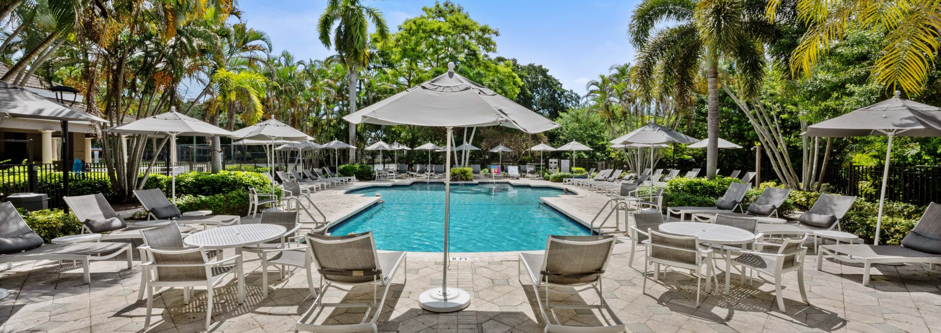 a pool with lounge chairs and umbrellas at The Palm Haven