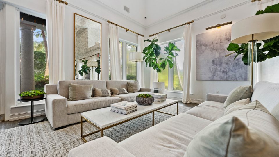 a living room with white furniture and a large window at The Palm Haven