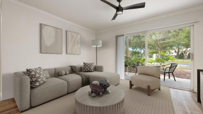 a living room with a ceiling fan and a couch at The Palm Haven