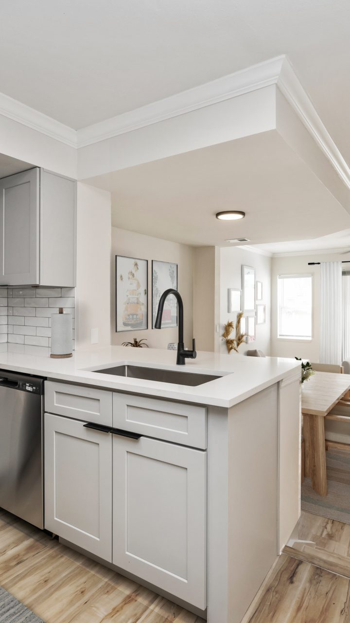 a kitchen with stainless steel appliances and white cabinets at The Palm Haven